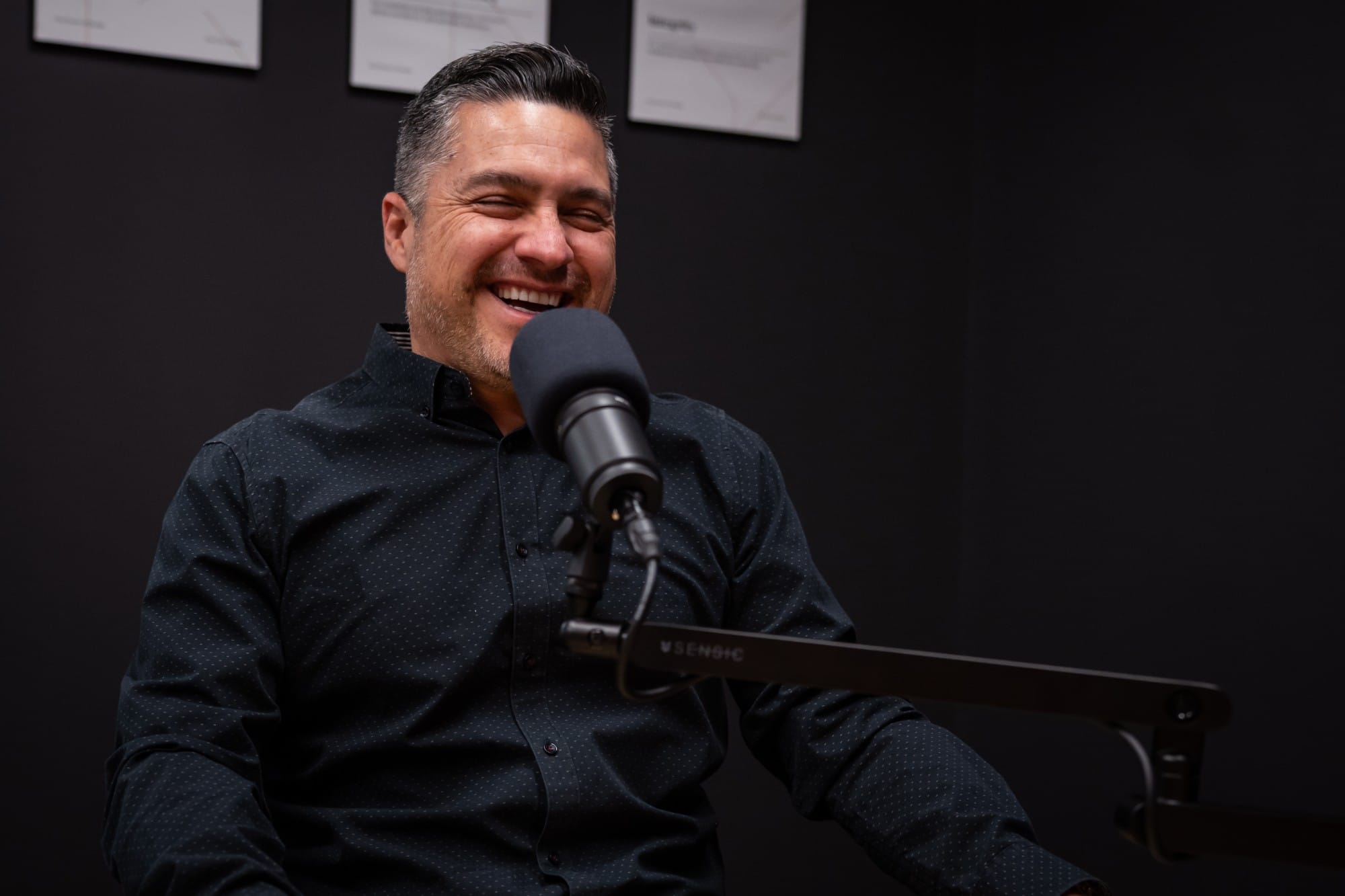 Jack Ossa, host of The Power of Design Podcast, laughing at the microphone